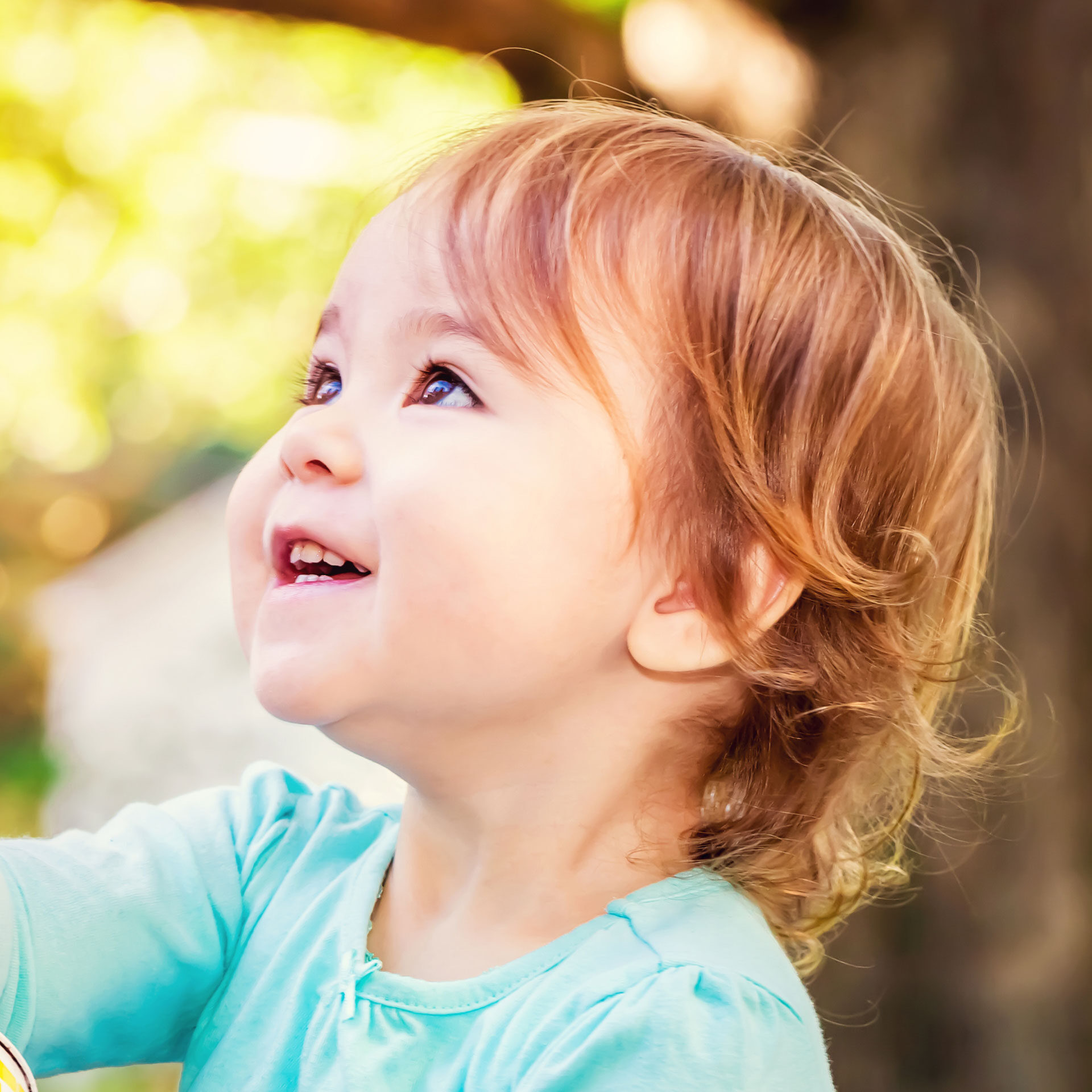 toddler girl smiling and looking up to the left