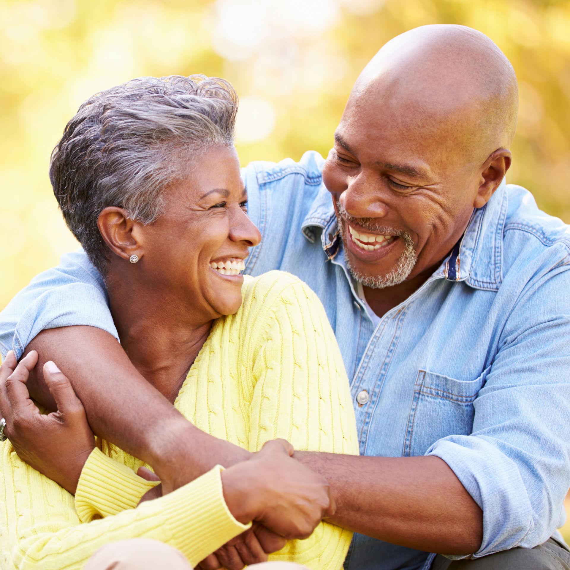 african american couple hugging and smiling at each other